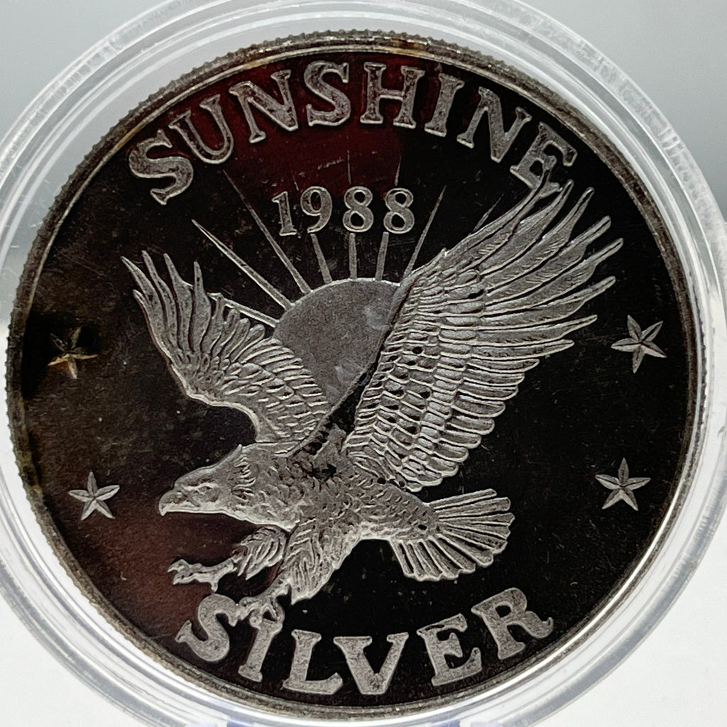 Silver coin with an eagle design and 'Sunshine Silver 1988' text.