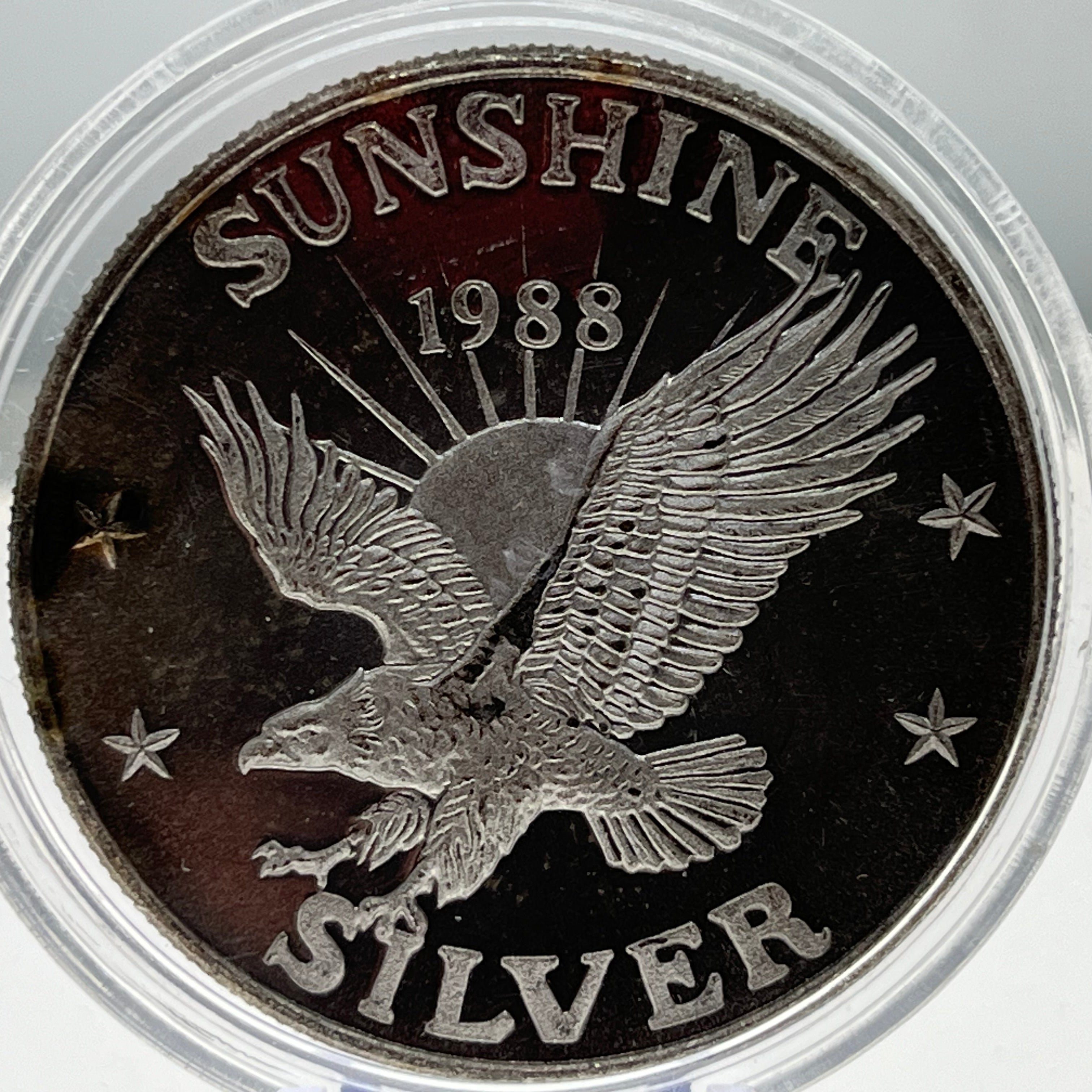 Silver coin with an eagle design and 'Sunshine Silver 1988' text.