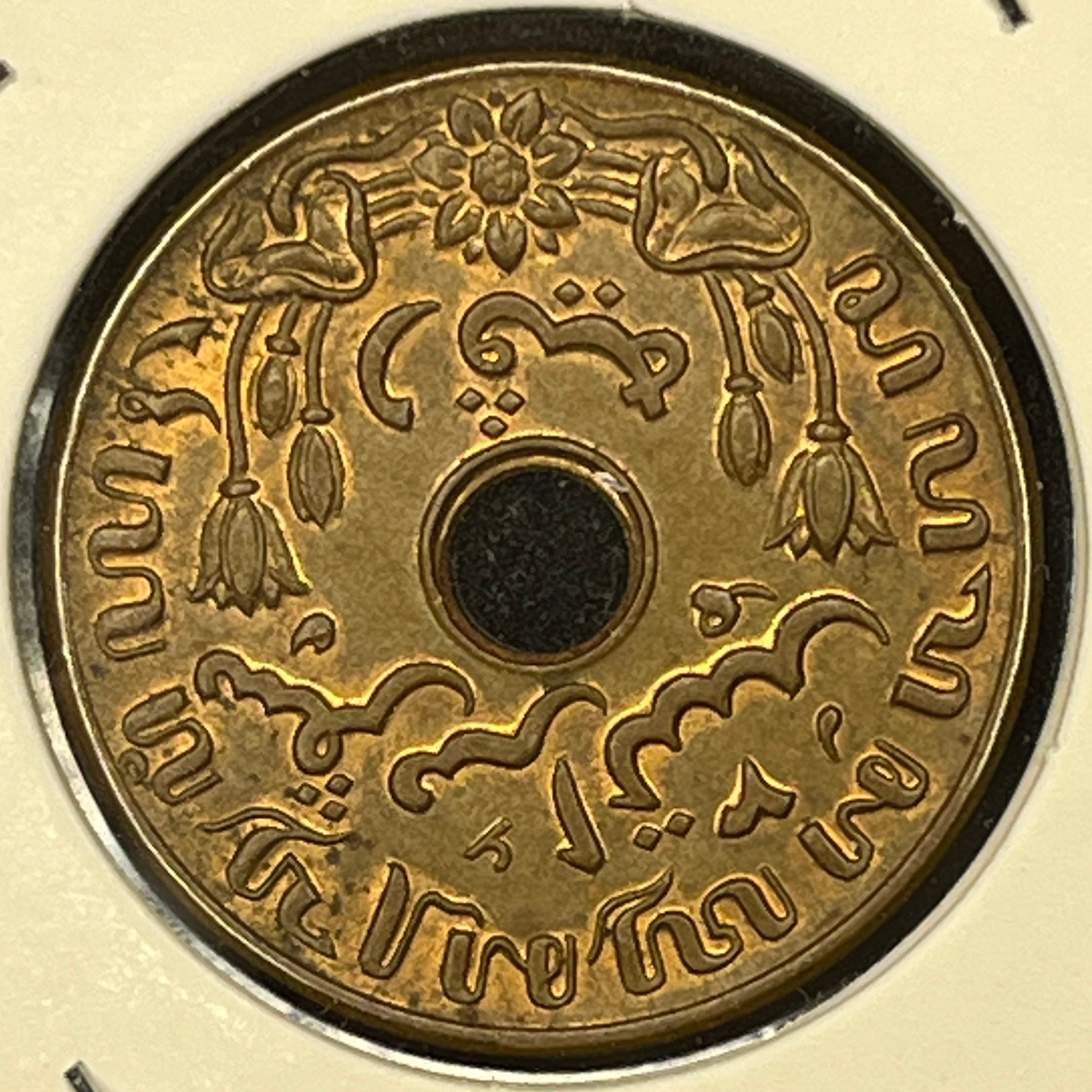 Coin with intricate designs on a beige background